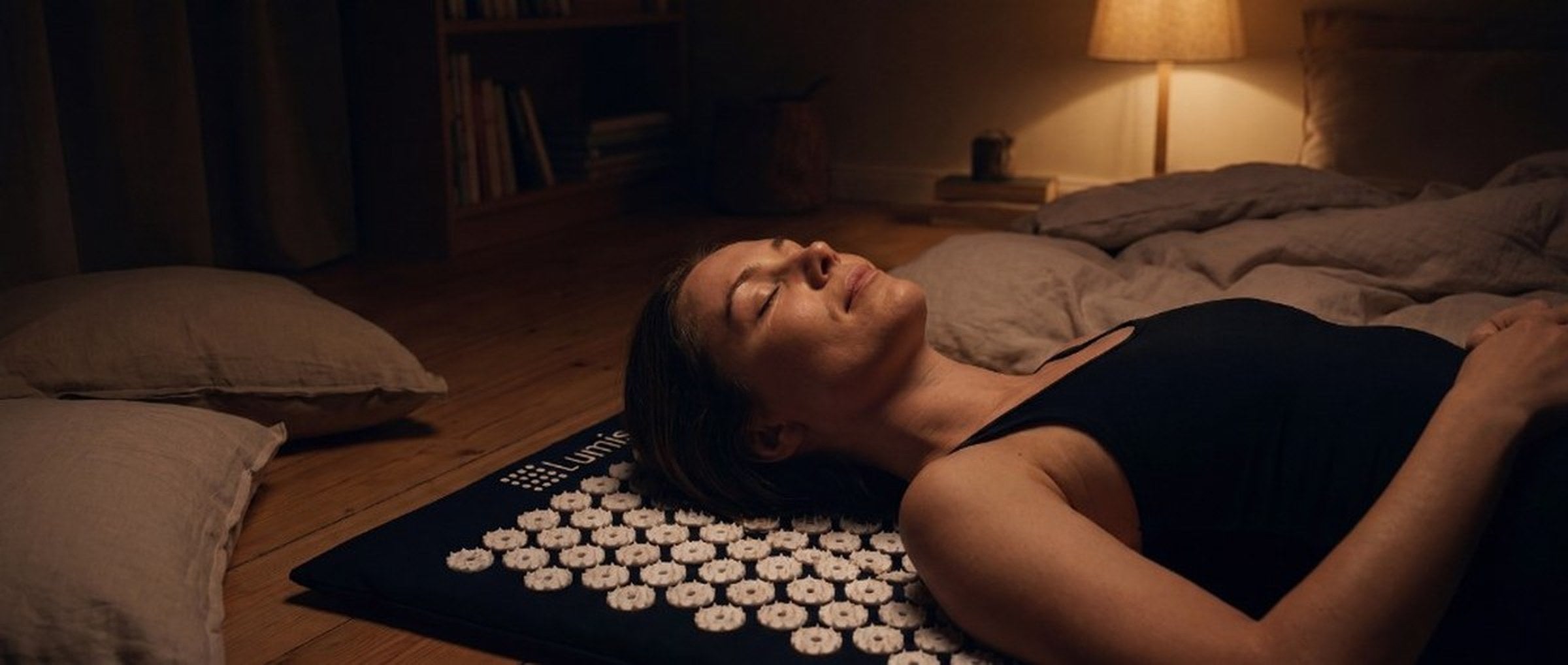 Woman relaxing on Lumis acupressure mat at home